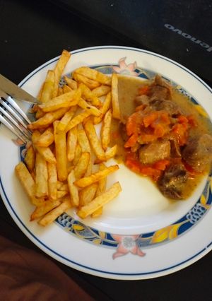 Una foto de Carne en salsa acompañada de patatas fritas