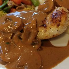 A picture of Pan Seared Chicken Breast smothered in a Crimini Mushroom Sauce.