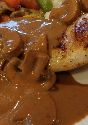 A picture of Pan Seared Chicken Breast smothered in a Crimini Mushroom Sauce.