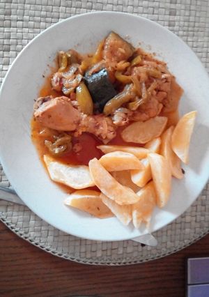 Una foto de Pollo encebollado con pimiento y calabacín