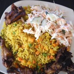 A picture of Fried rice with chicken and coleslaw.