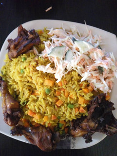 A picture of Fried rice with chicken and coleslaw.