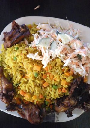 A picture of Fried rice with chicken and coleslaw.
