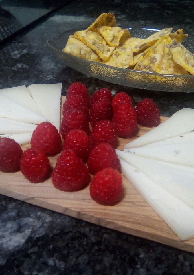 Una foto de Aperitivo: Frambuesas, queso de cabra y triángulos de maíz con legumbres