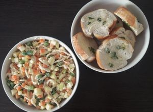 Una foto de Ensalada de pollo con tostadas de pan al ajillo.