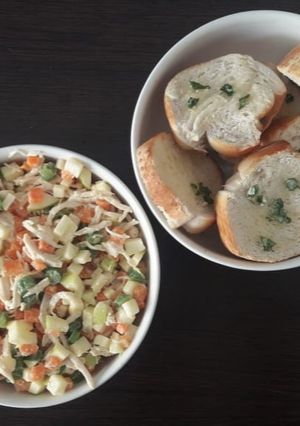 Una foto de Ensalada de pollo con tostadas de pan al ajillo.