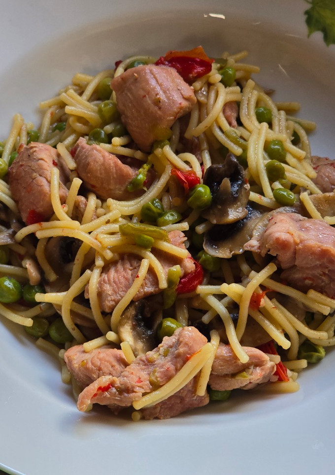 Una foto de Pavo salteado con fideos, guisantes y pimientos