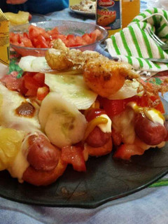 Una foto de Panchos (frankfruter) con pan de Viena, verdura y fruta