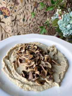 Una foto de Hummus con champiñones salteados