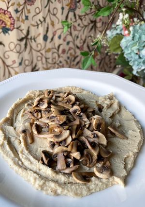 Una foto de Hummus con champiñones salteados