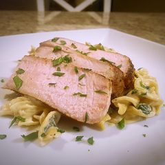 A picture of Pork chops with lemon garlic and spinach cream pasta.
