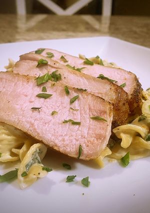A picture of Pork chops with lemon garlic and spinach cream pasta.