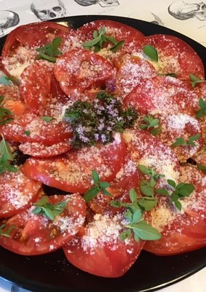Une photo de Salade de tomates cœur de bœuf,parmesan,fleurs et feuilles de basilic