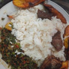 A picture of White rice, vegetable, plantain and fried beef.