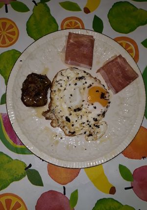 Una foto de Huevo frito con trufa negra rallada y guarnición