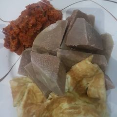 A picture of Brown yam and mince meat sauce with fried egg.