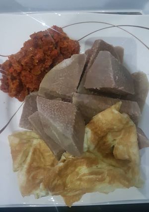 A picture of Brown yam and mince meat sauce with fried egg.