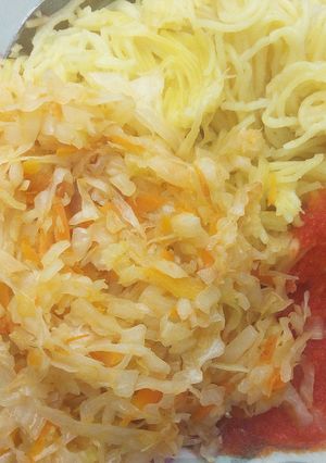 A picture of Spaghetti served with steamed cabbage and tomatoes past.