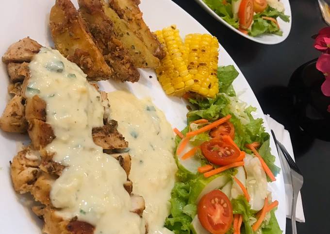 Grilled chicken steak, bechamel sauce, crispy potato wedges and garden salad