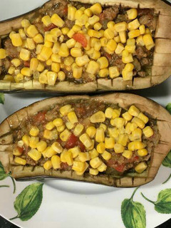 Una foto de Berenjenas rellenas y maíz