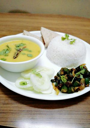 A picture of Healthy dal, chawal,bhindi fry,roti and salad.