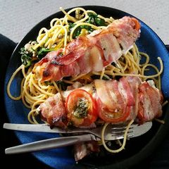 A picture of Bacon - wrapped fish with spaghetti.