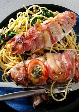 A picture of Bacon - wrapped fish with spaghetti.