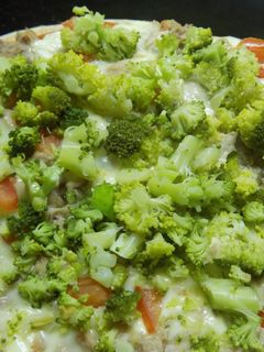 Una foto de Pizza con brócoli, queso y atún