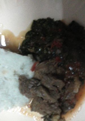 A picture of Beef stew with kales and Ugali.