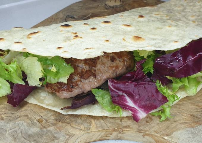 Super piadina con salsiccia cipolla insalata