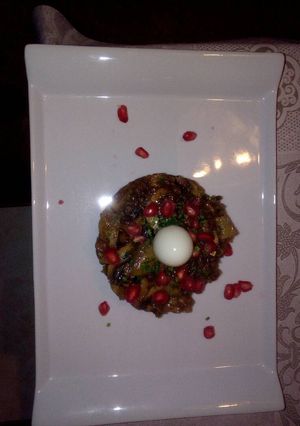 Una foto de Champiñones con ajo negro y granada con huevo de codorniz