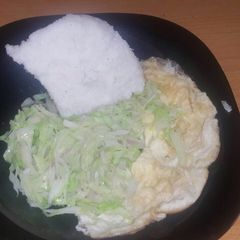A picture of Fried cabbage accompanied with ugali and Fried egg.