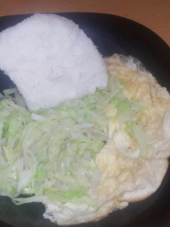 A picture of Fried cabbage accompanied with ugali and Fried egg.