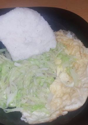 A picture of Fried cabbage accompanied with ugali and Fried egg.