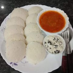 A picture of Idli, sambar, chutney.