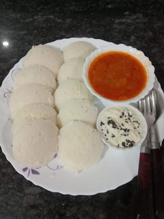 A picture of Idli, sambar, chutney.
