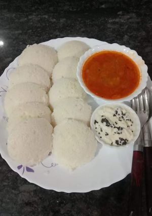 A picture of Idli, sambar, chutney.