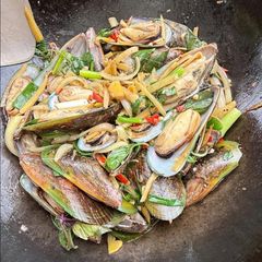 A picture of Stir-fry mussels with ginger and basil.
