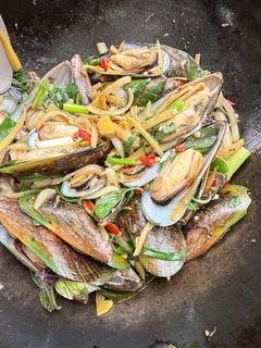 A picture of Stir-fry mussels with ginger and basil.