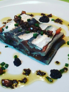 Una foto de Milhoja de sardinas marinadas y tomate confitado