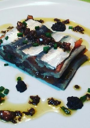 Una foto de Milhoja de sardinas marinadas y tomate confitado