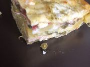 Una foto di lasagna con prosciutto cotto