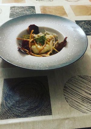 Una foto de Huevo poché con alcachofas confitadas y crujiente de jamón y yuca