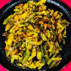 A picture of Runner beans and potato fry with onion and onion greens.