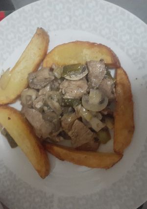 Una foto de Pollo al champiñón con papas doradas