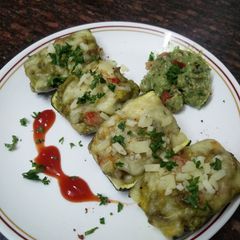 A picture of Zucchini stuffed with cheesy Guacamole.