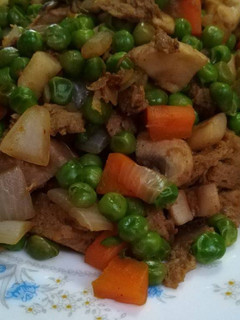 Una foto de Seitán con guisantes y champiñones