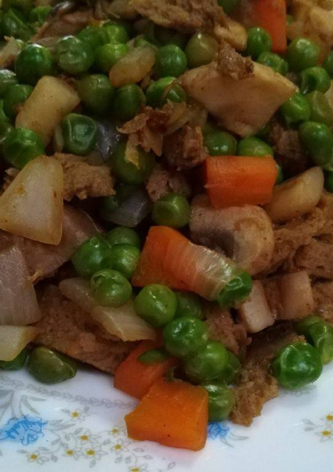 Una foto de Seitán con guisantes y champiñones