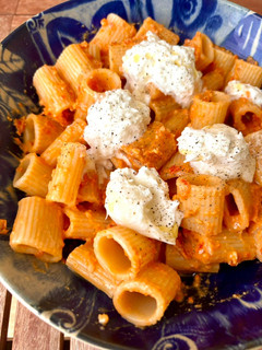 Una foto de Rigatoni con pesto rojo y burrata