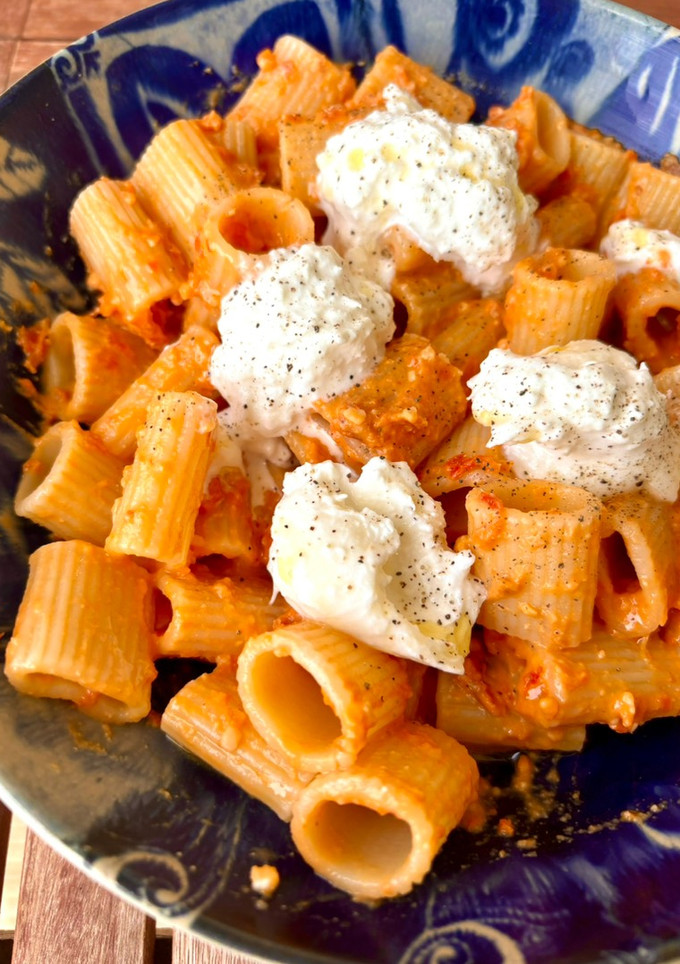 Una foto de Rigatoni con pesto rojo y burrata